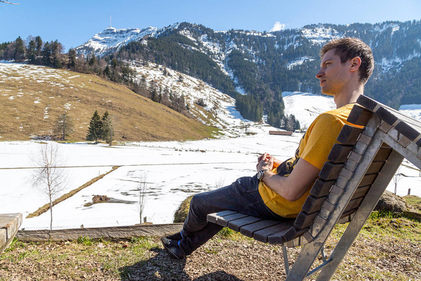 Young man sitting in Rigi in Switzerland watching nature and mountains - Fotografie, Obrázek
