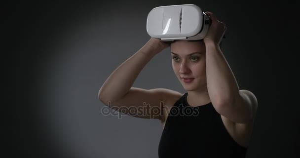 Young short haired woman puts on virtual reality headset - Video, Çekim