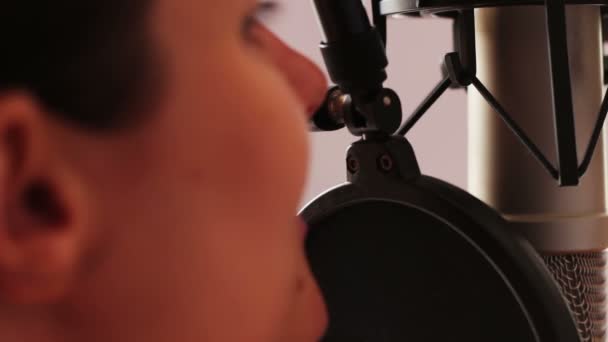 Nuori seksikäs tyttö antaa haastattelun tai kirjoittaa puheen studiomikrofonilla
 - Materiaali, video