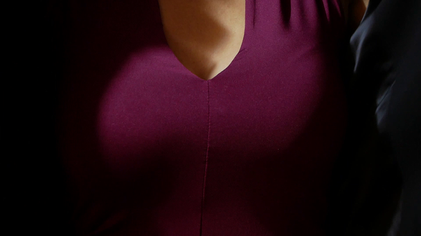 美しい胸を持つ女性は、黒のジャケットを置く - 映像、動画