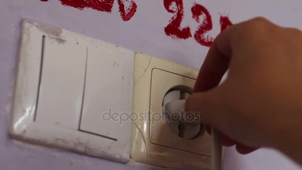 La mano femminile inserisce una spina in una presa 220 volt
 - Filmati, video