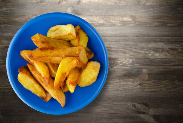  fry potatoes on a wooden background  - Fotografie, Obrázek