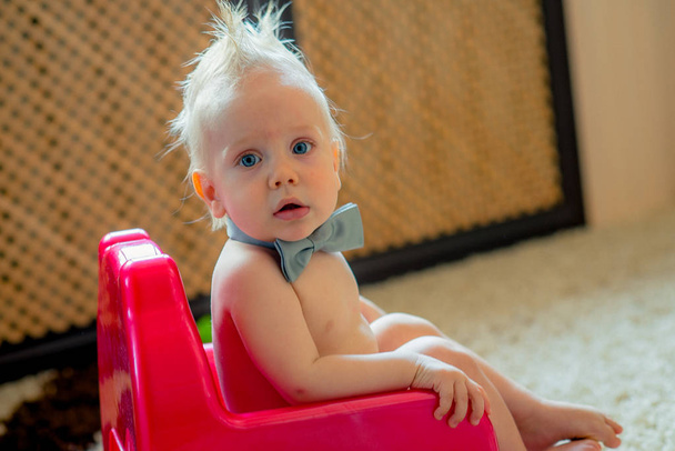 グリーン ホーム インテリアでトイレに座っている女の赤ちゃん - 写真・画像