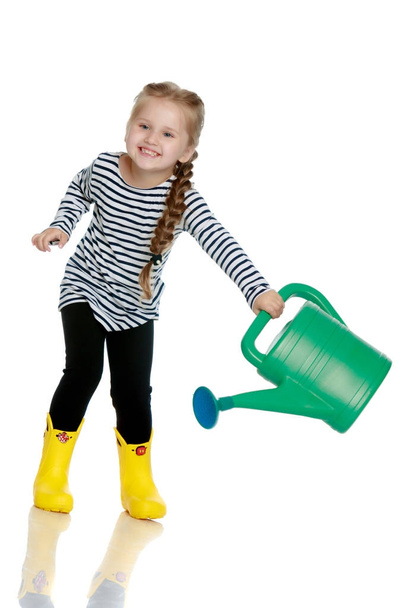 A little girl is watering a garden. - Zdjęcie, obraz