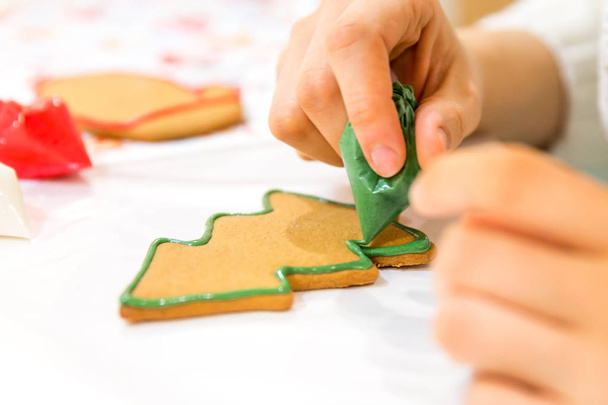 Menina pintura de Natal pão de gengibre no estúdio de arte com doce cereja
 - Foto, Imagem