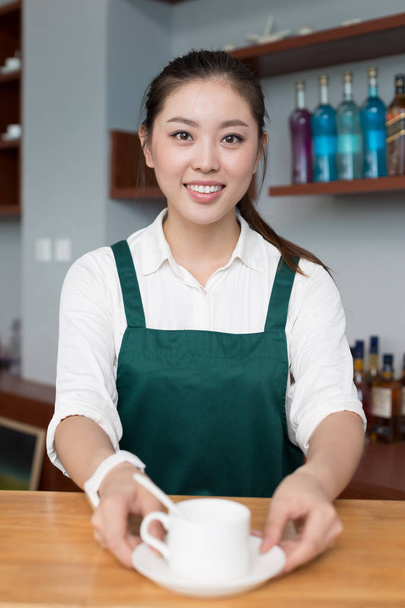 mooie jonge vrouw werkt in café - Foto, afbeelding