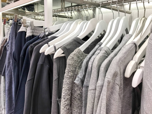 roupas penduradas em um rack em uma loja de roupas de grife
 - Foto, Imagem