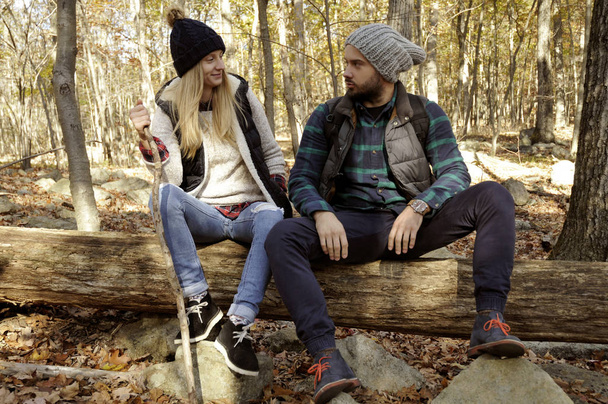 Couple is sitting in autumn forest in the mountains. Hiking and traveling - Φωτογραφία, εικόνα