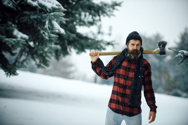 Man with beard in winter forest with snow hold axe. - Fotoğraf, Görsel