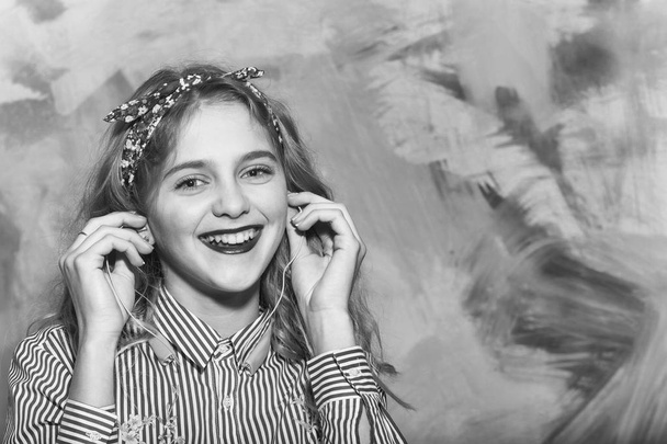 Cheerful pretty girl listens to music with earphones - Valokuva, kuva