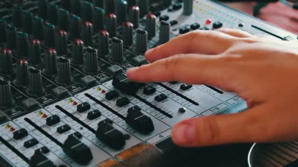 Consola DJ o mezclador, la mano presiona las palancas y botones del mando a distancia
 - Metraje, vídeo