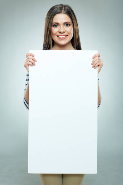 smiling woman wearing striped shirt holding white banner  - Foto, immagini