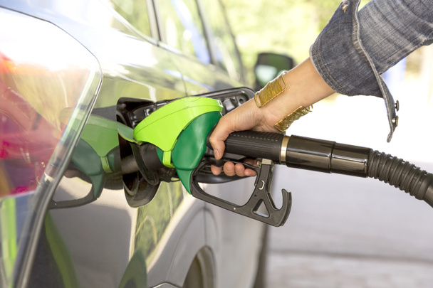 A woman's hand filling up gas - Фото, изображение