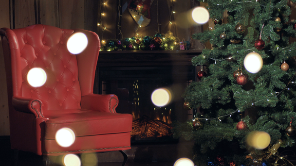 Boże Narodzenie wnętrza kominka. Santa Claus krzesło w pobliżu choinki. 4k. - Materiał filmowy, wideo