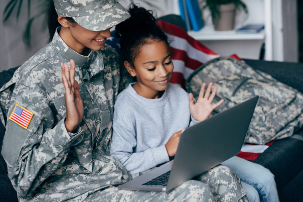 sotilas ja lapsi tekee videopuhelun
  - Valokuva, kuva
