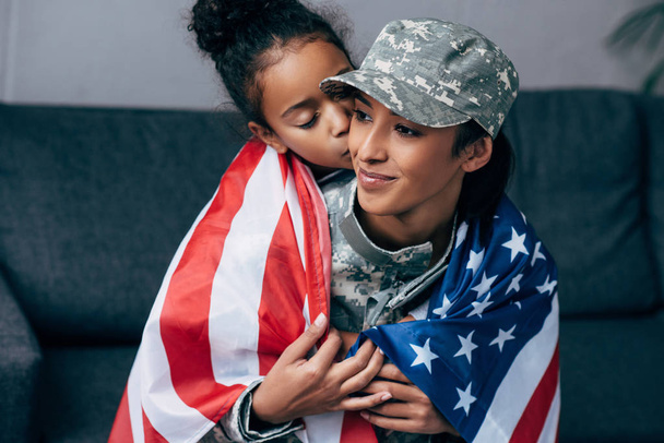 daughter kissing mother in military uniform  - Фото, изображение