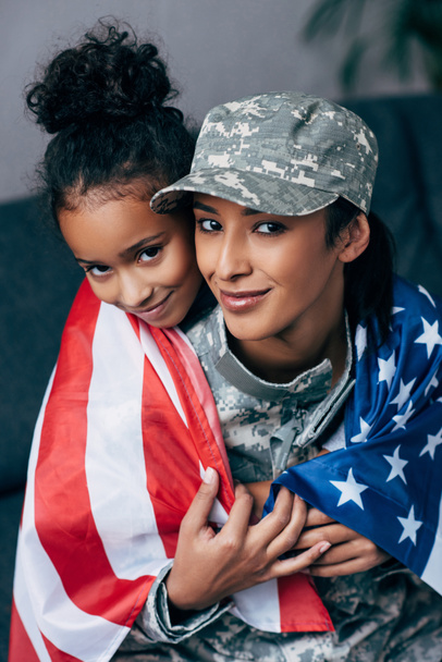 daughter and soldier wrapped with american flag - Fotoğraf, Görsel