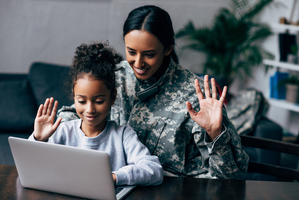 woman in military uniform and daughter with laptop - Foto, immagini