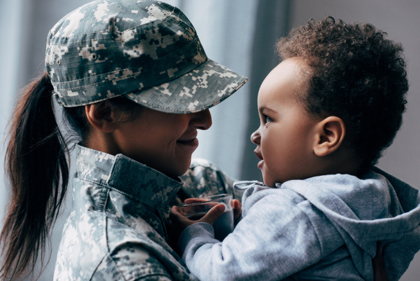 mother in military uniform with little son - Foto, imagen