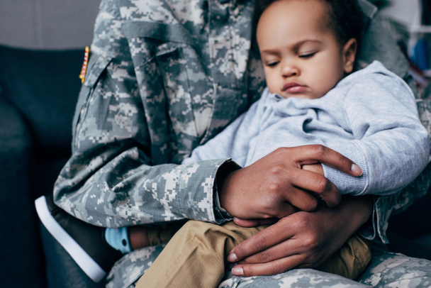 soldier with sleeping son - Φωτογραφία, εικόνα