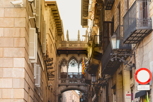 dark atmosphere with a scorching sun above the buildings in a street of the Gothic district of barcelona - Foto, immagini