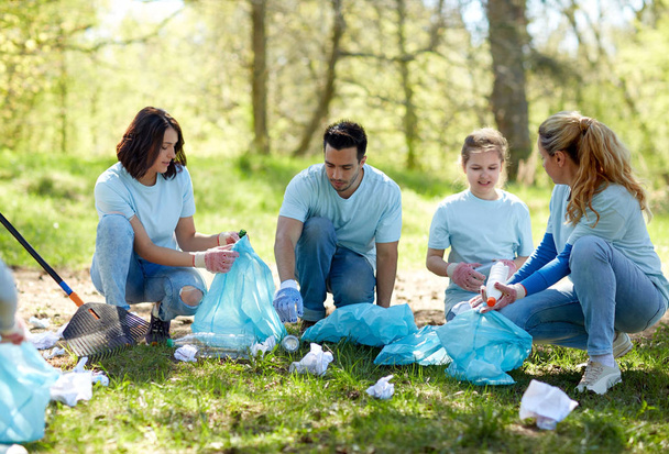 volunteers with garbage bags cleaning park area - Fotoğraf, Görsel