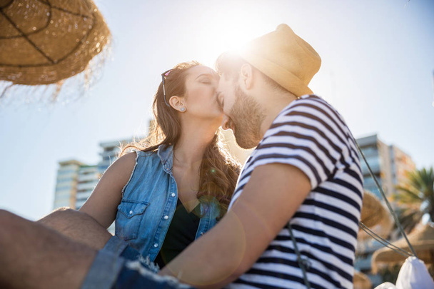 Young woman kissing her boyfriend on forehead in sunlight - Foto, afbeelding