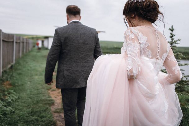 Novomanželé procházka u jezera na jejich svatební den - Fotografie, Obrázek