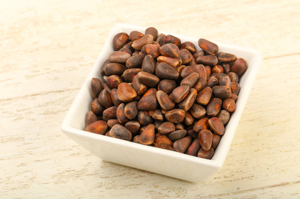 Cedar nuts heap in bowl  - Foto, afbeelding