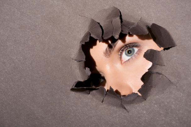 woman peeking out of hole in paper - Photo, Image