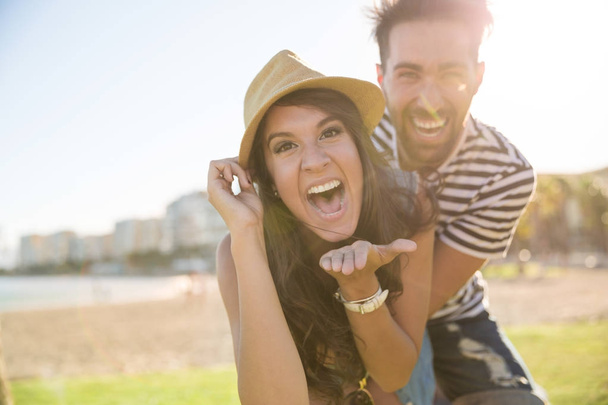 Happy woman in hat laughing with her boyfriend outside - Photo, image