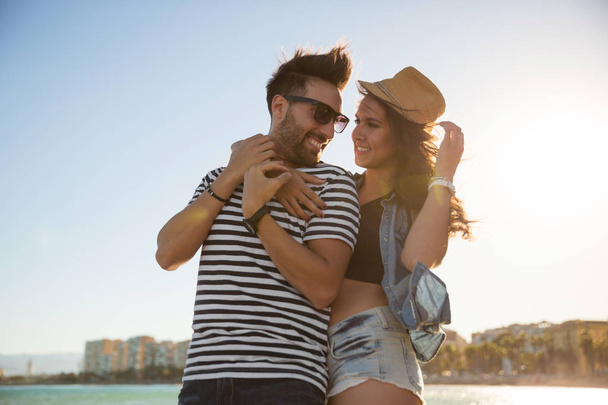 Happy woman in hat embracing her boyfriend looking at him - Photo, image