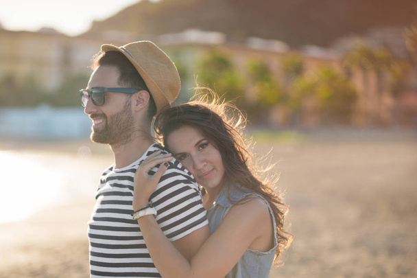 Happy woman embracing her boyfriend at seaside smiling - Fotó, kép