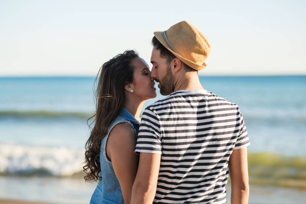 Casal em pé à beira-mar beijando
 - Foto, Imagem
