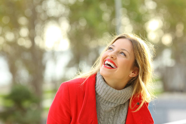 Carefree happy girl laughing looking above outdoors - Fotó, kép