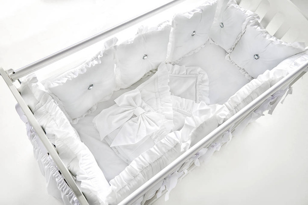 Beyaz ve yumuşak yastıkları ile Bebek karyolası/beşik - Fotoğraf, Görsel