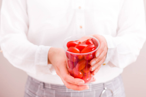 Donna d'affari in possesso di tazza con pomodori freschi
. - Foto, immagini