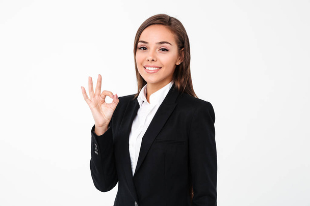 Cheerful business woman showing okay gesture - Fotó, kép