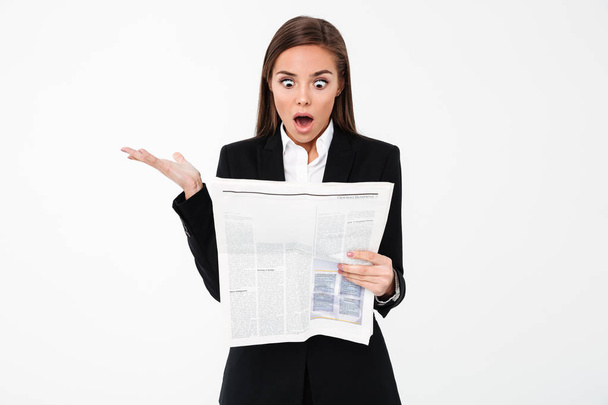 Shocked business woman holding newspaper. - Foto, afbeelding