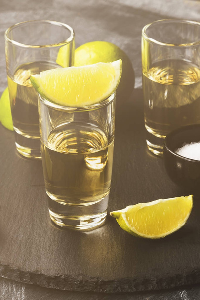 Tequila with lime and salt on a dark background. Toned - Photo, Image