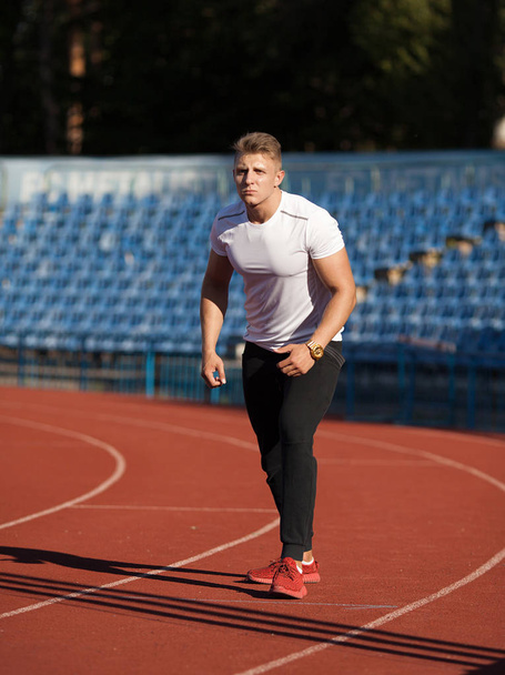 Man ready to start running on a track - Foto, imagen