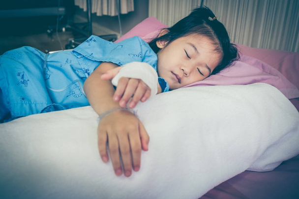 Choroby azjatycki dziecko przyjęte w szpitalu z soli fizjologicznej dożylne (Iv) kroplówki z strony. - Zdjęcie, obraz