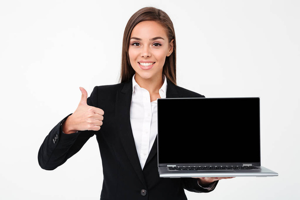 Happy pretty businesswoman showing display of laptop with thumbs up - Photo, image
