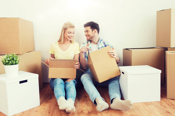 smiling couple with many boxes moving to new home - Foto, Imagen
