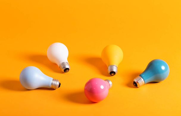 Colored light bulbs on a yellow background - Foto, Bild