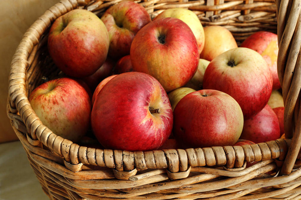 Las manzanas maduras brillantes sabrosas en la cesta
 - Foto, imagen