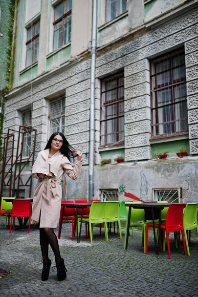 Black hair sexy woman in glasses and coat posed at street of old - Foto, Imagem