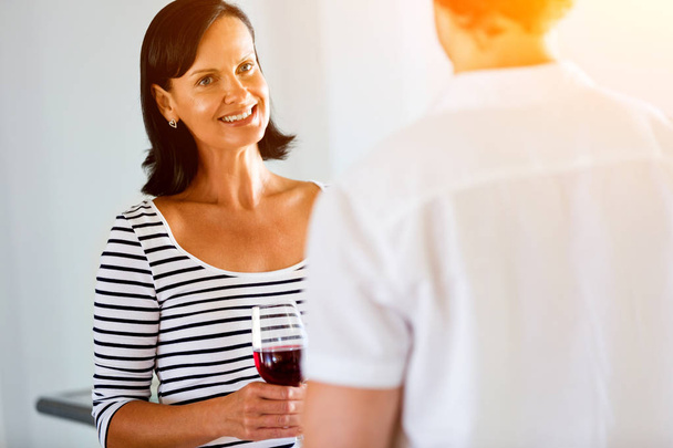 Woman with a glass of wine talking to a man - Φωτογραφία, εικόνα