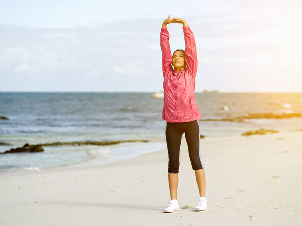 Young woman at the beach doing exercises - Foto, Imagen