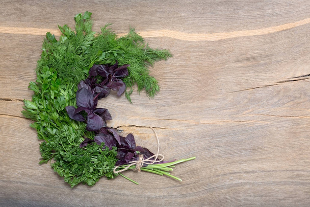 Bunch of greenery and basil on wooden background. - Photo, Image